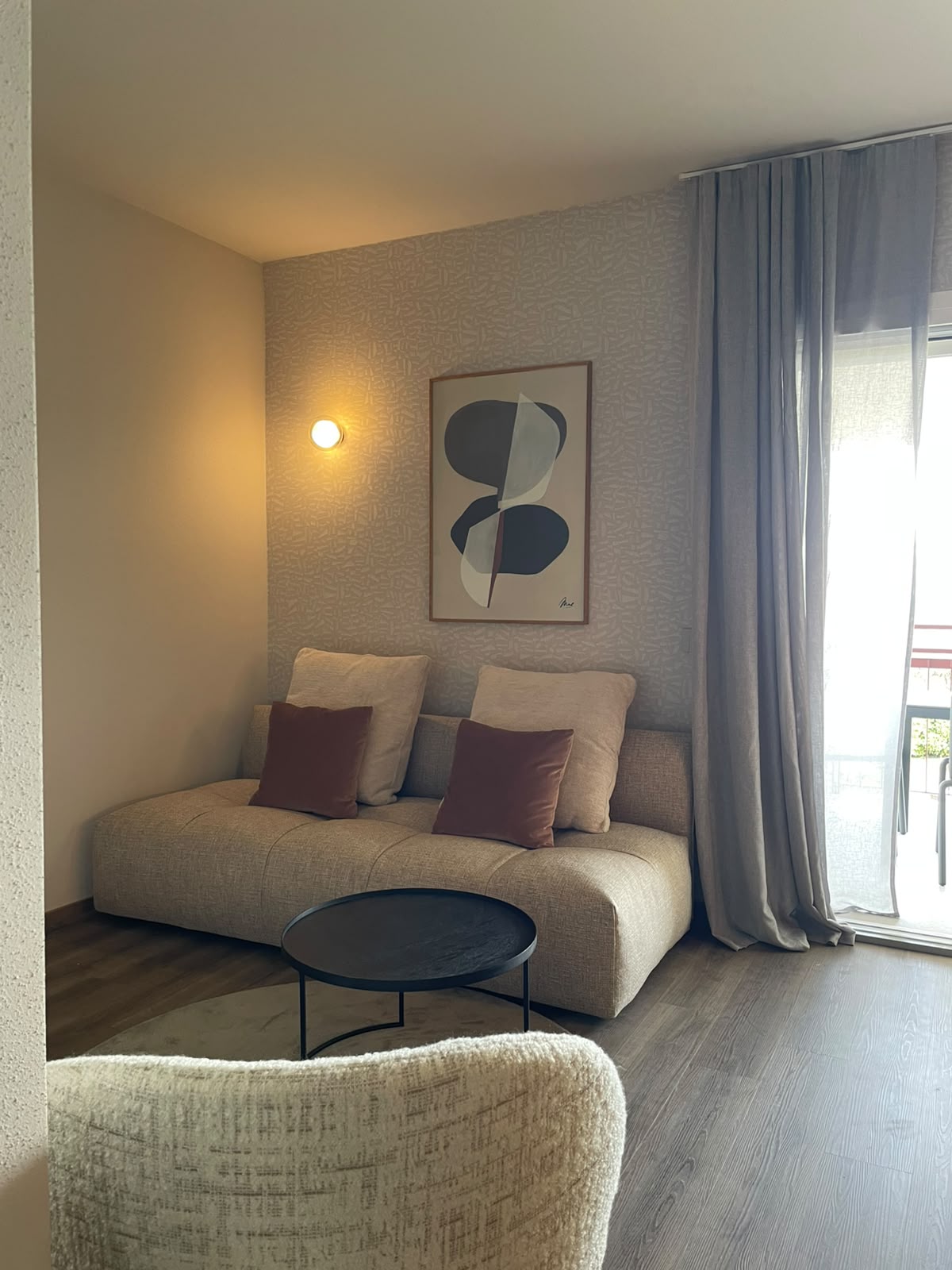 Wohnbereich mit Sofa, Beistelltisch und bodentiefem Fenster