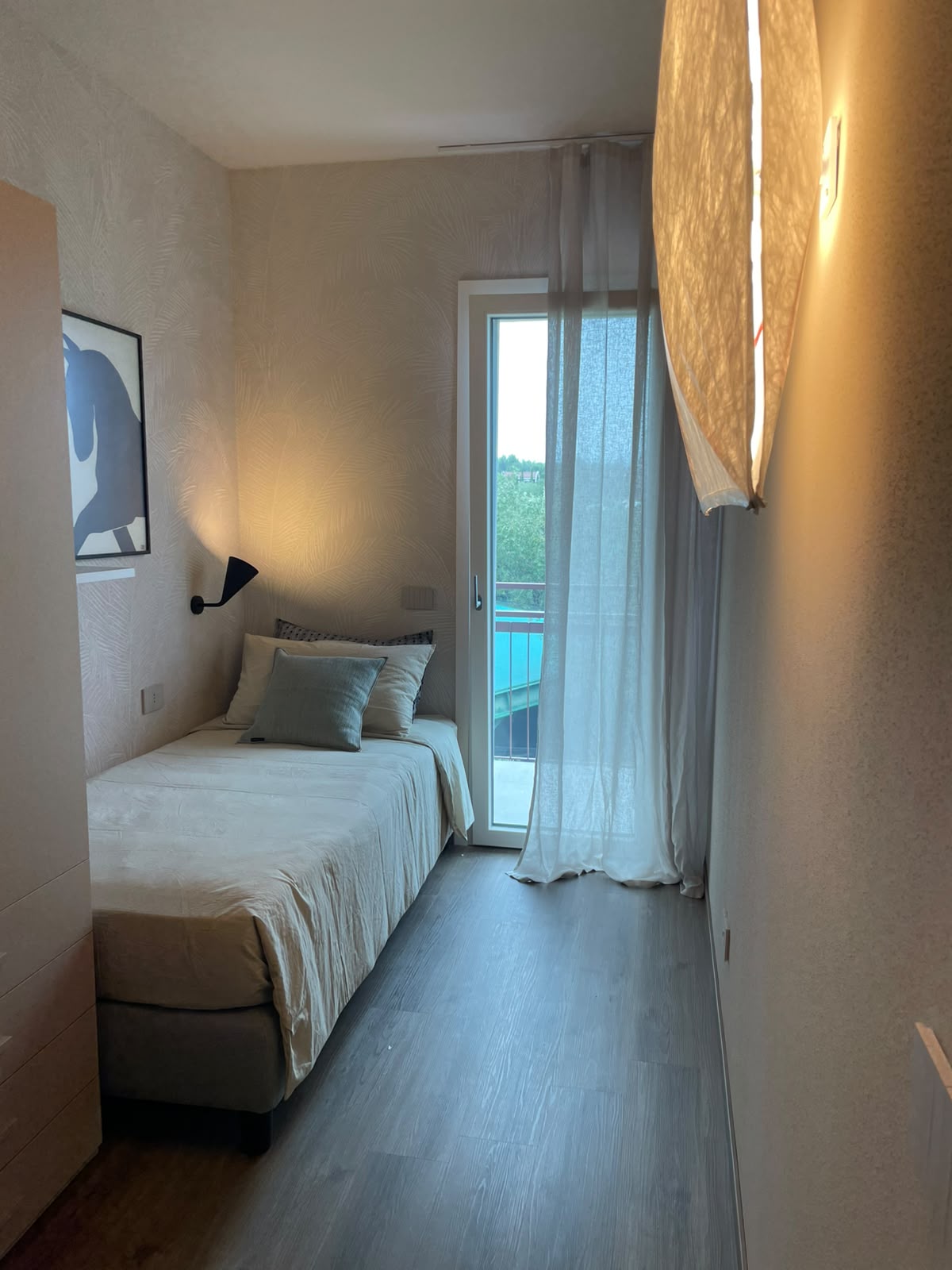 Schlafzimmer mit Einzelbett und Terrassentür