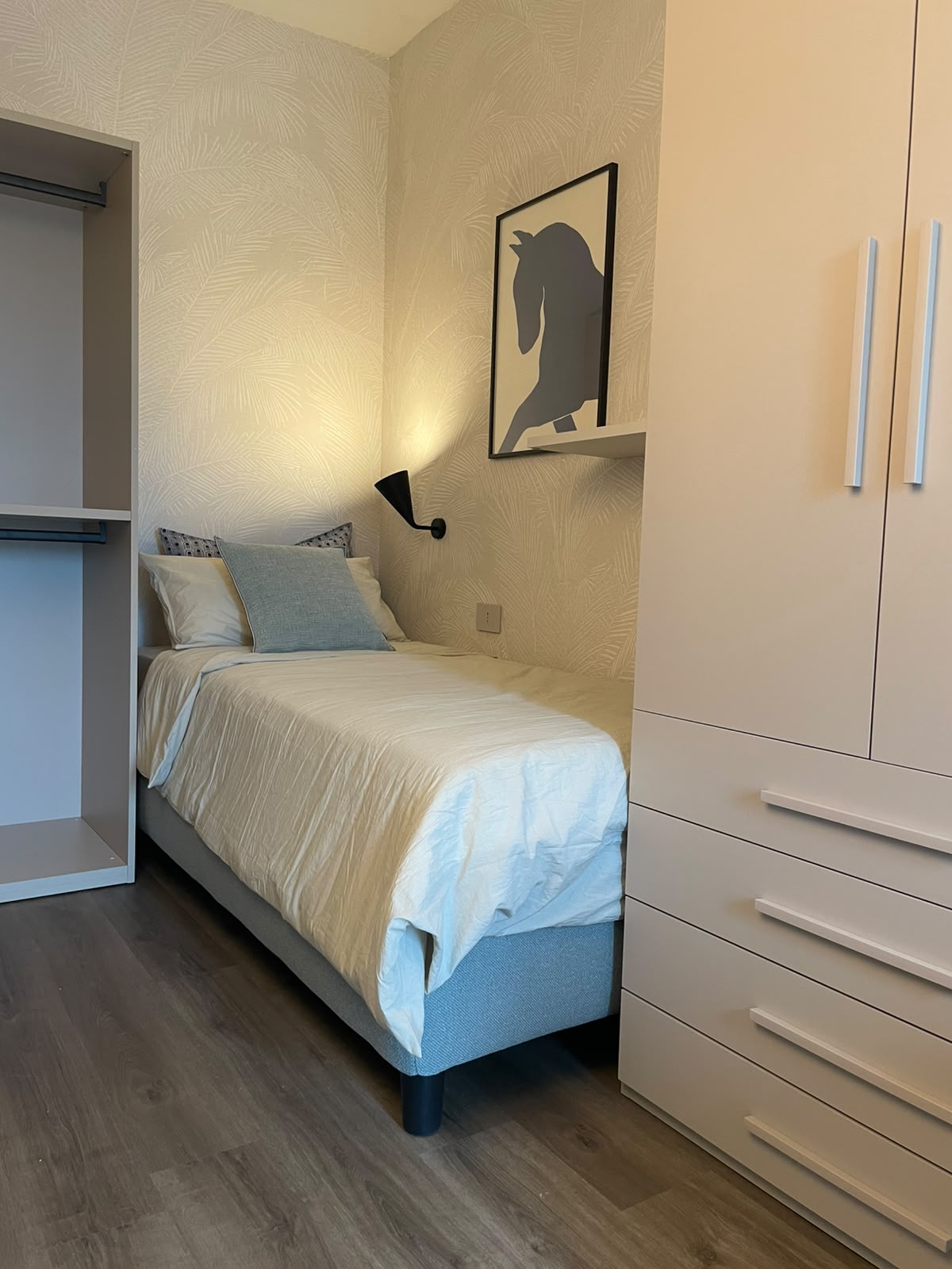 Schlafzimmer mit Einzelbett und Einbauschränken